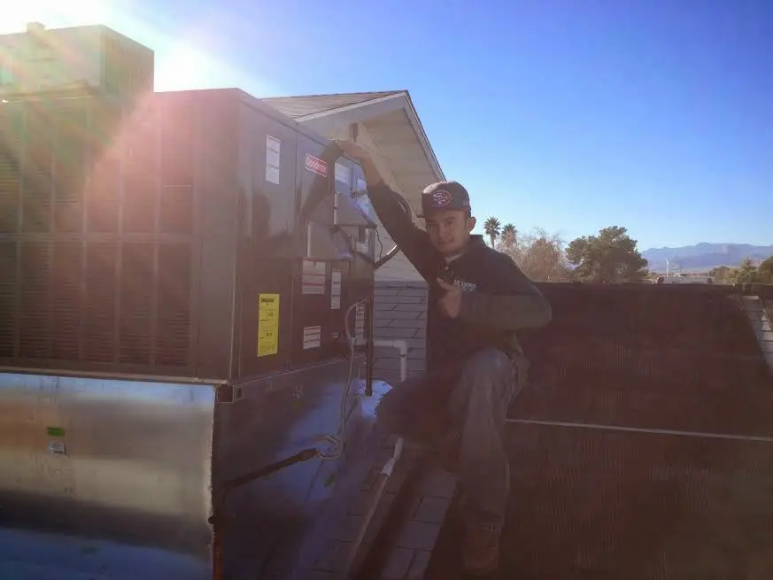 HVAC technician performing AC Tune-Up on a rooftop unit in Florence